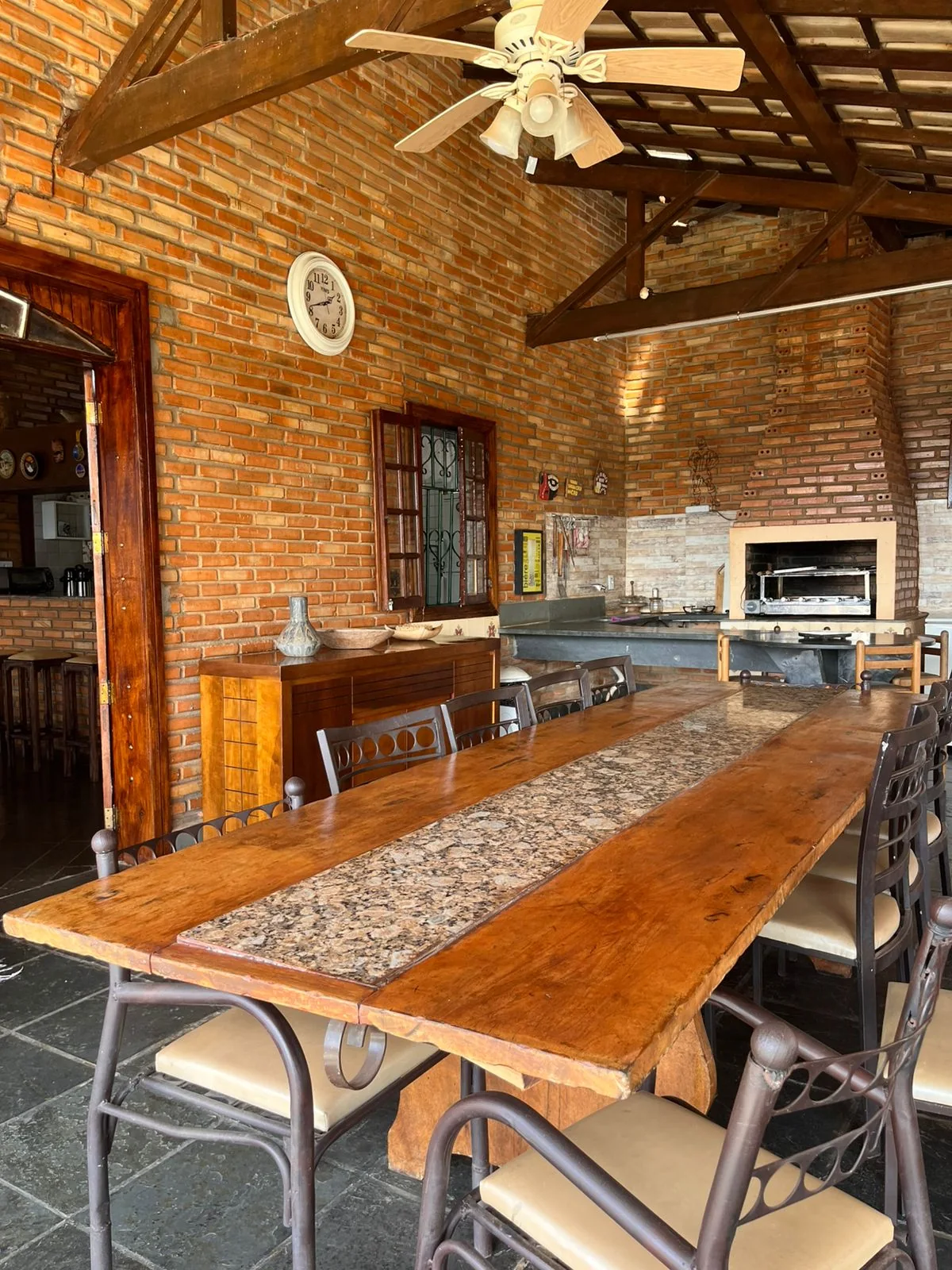 Área coberta de churrasqueira com mesa grande