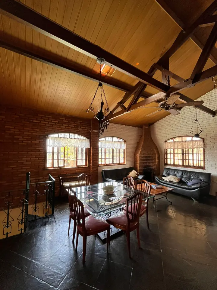 Sala de estar interna com mesa de jantar e sofás