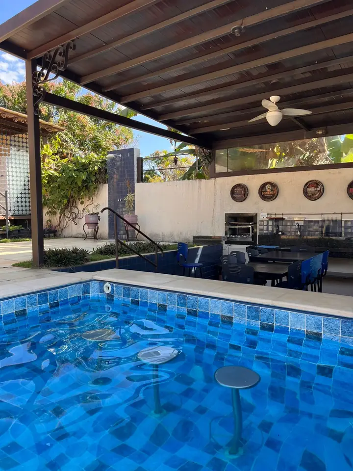 Piscina com bancos para sentar próxima à churrasqueira